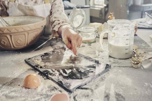 MediaMarkt toestel ligt op het keukenaanrecht en zit onder de ingrediënten en klodders deeg